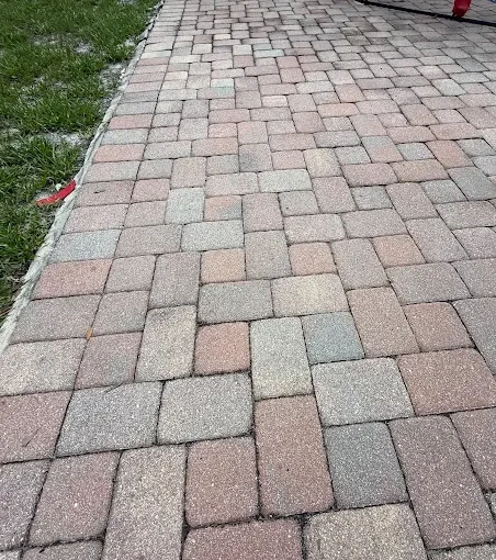 Close-up of a tumbled paver walkway running alongside a lawn